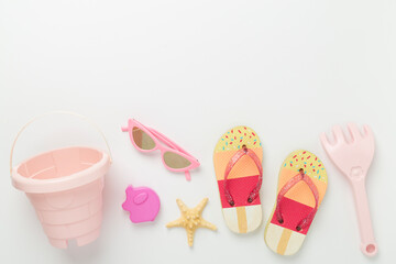 Children's flip flops and beach toys on color background,,top view