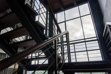 Obraz premium Modern Interior Staircase with Large Window Allowing Natural Light Inside