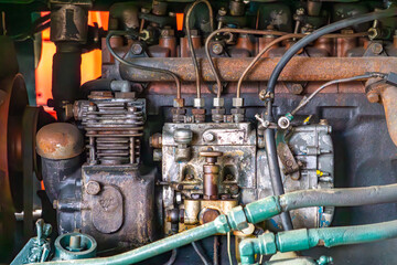 Close-up view of a diesel engine. Visible are the fuel injection system components, fuel lines, injection pumps, and parts of the cooling and lubrication systems. The engine shows signs of use, dirt, 