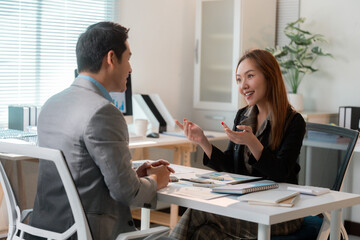 Businesswoman explaining marketing strategy to businessman during corporate meeting