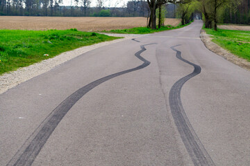 country road with clear skid marks. The black stripe of tires on the asphalt indicates a sudden stop of the vehicle as a result of sudden braking.