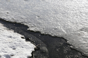 Large crack in the ice close-up, melting ice in spring.