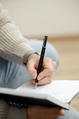 Man Sitting on Couch Writing in Notebook in a Creative Environment