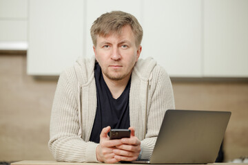 Man in the kitchen talking on the phone