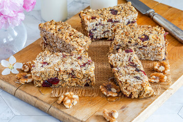 Homemade breakfast bars made of rolled oats, nuts, dried cranberries and honey