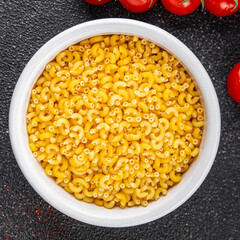 Macaroni pasta raw coquillette appetizer dish organic product fresh tasty gourmet food background on the table rustic food top view copy space