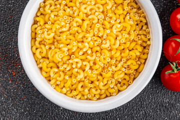 Macaroni pasta raw coquillette appetizer dish organic product fresh tasty gourmet food background on the table rustic food top view copy space