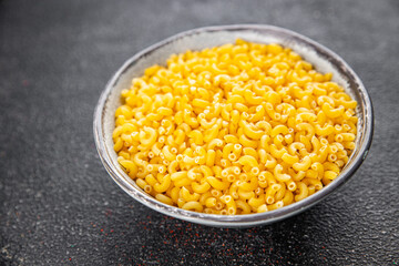 Macaroni pasta raw coquillette appetizer dish organic product fresh tasty gourmet food background on the table rustic food top view copy space