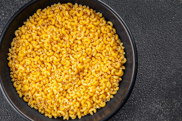 Macaroni pasta raw coquillette appetizer dish organic product fresh tasty gourmet food background on the table rustic food top view copy space