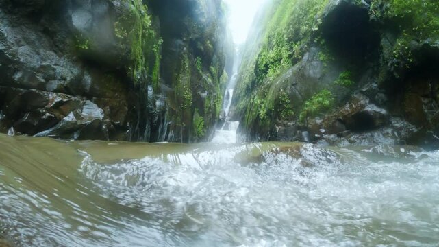 4K low angle close up shot of running water of stream comes form Satsada waterfall in Maharashtra, India. Waterfall flowing between two mountain creek during monsoon. 