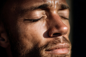 Obraz premium A close up of a man's face with his eyes closed