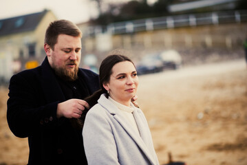 Caucasian couple enjoying beach moments with hair styling