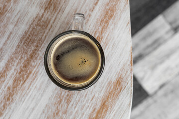 A coffee mug sits on a wooden table with blended cream and honey shades, highlighting natural...