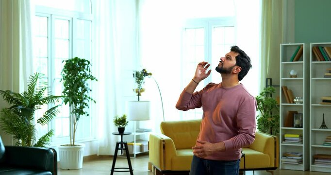 Indian Asian young couple trying to kill mosquitos using a battery-operated electric insect killer racquet in modern living room, fighting mosquito infestation at home with energetic expressions