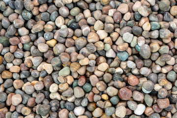 Colorful polished stones or semi-precious gems arranged tightly together, creating a vibrant and glossy texture.