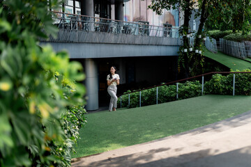 Young woman using smartphone in a modern green urban space