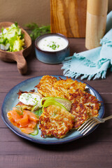 Hash browns with smoked salmon, cucumbers and yogurt. Vegetable fritters, latkes, potato cakes. Vegetable pancakes
