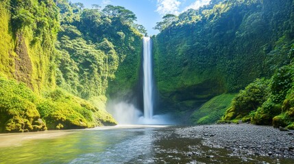 Fototapeta premium A tall cascading waterfall flowing into a calm body of water