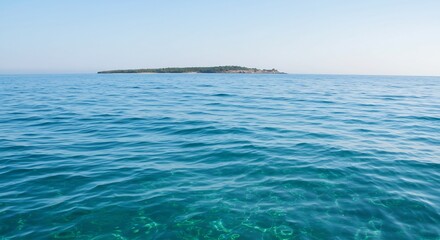 Obraz premium 穏やかな青い海 遠く小さく島影 透き通る水面