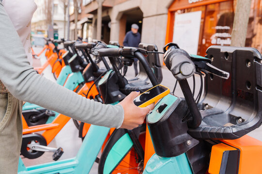 Woman using smartphone to rent public bikes sharing service