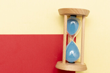 Hourglass with a flowing blue sand inside	