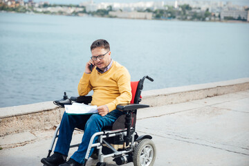 Disabled man in wheelchair wheelchair working on laptop negotiation