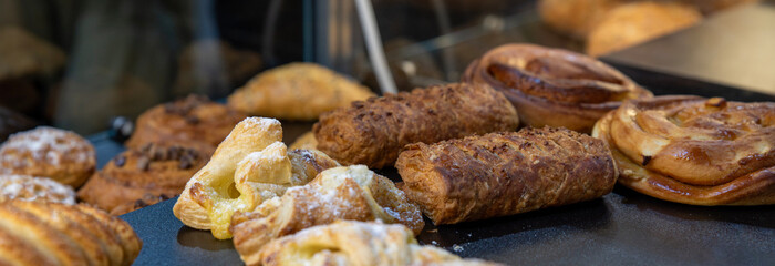 Various puff pastries with sugar crust in a bakery window