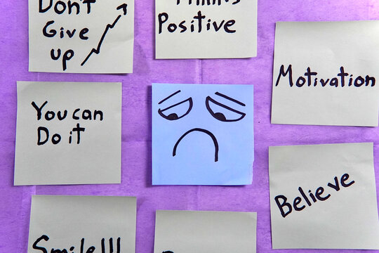 Sticky notes with motivational messages around a sticky note with a sad face.