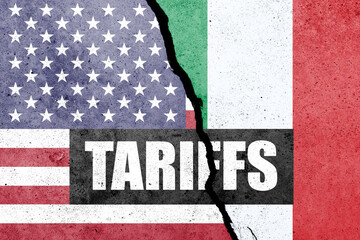 USA and Italy flags painted on the concrete wall with word TARIFFS. Duty, trade, customs and tariffs war