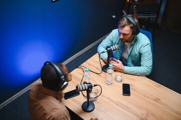Podcast presenter having live discussion with man, streaming it for audience on internet...