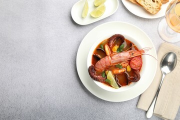 Tasty seafood soup served on light grey table, flat lay. Space for text
