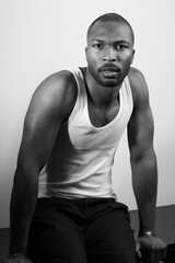 Fototapeta premium Monochrome portrait of a muscular man wearing a tank top and bracelets