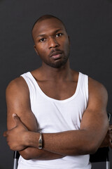 Fototapeta premium Portrait of a man in a white tank top with arms crossed looking forward