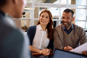 Happy couple having a meeting with their bank manager in the office.