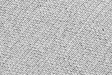 Texture of white natural fabric with large diagonal weaving. Surface, structure of upholstery or carpet material, cloth background close up.