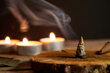 Incense Cone Burning on Wooden Base With Candles Glowing Softly