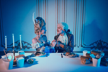 Aristocratic couple in thematic retro costumes dining in an elegant ambiance with a blend of modern and historic elements