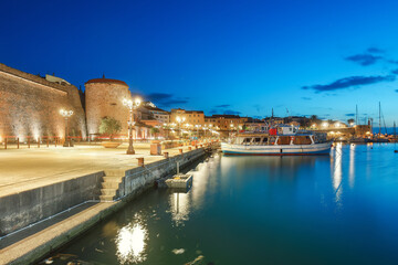 Fototapeta premium Unbelivable Night view of the Alghero Marina yacht port at the Gulf of Alghero with anchored sailboats