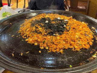 Sizzling Kimchi Fried Rice on a Hot Plate with Seaweed Topping