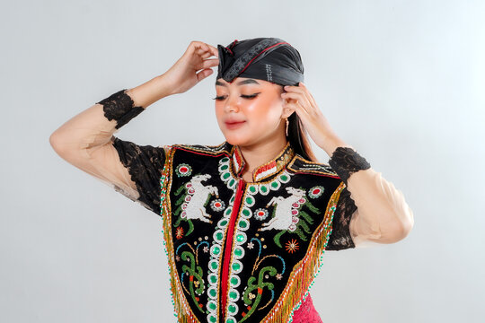 A Javanese traditional dancer gracefully adjusts her headpiece while wearing an intricate Jathilan costume, showcasing elegance, beauty, and the cultural heritage of Indonesia.
