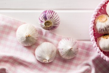 Solo glove garlic bulbs on white table. Top view.