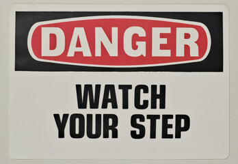 Danger watch your step safety sign notice on wall industrial occupation.