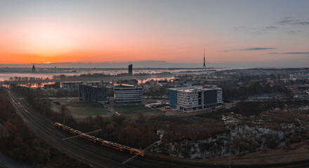 Serene sunrise in Riga, Latvia, featuring the Riga TV Tower, Daugava River, modern buildings, a...