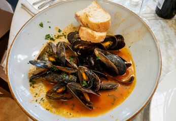 Traditional tomato bouillabaisse soup with mussels. Seafood background. Seafood in a white plate.