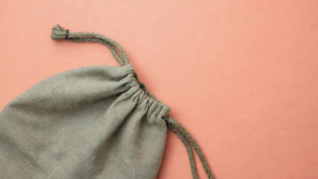 Olive Green Cotton Drawstring Bag on Coral Background, Minimalist Aesthetic, Top View