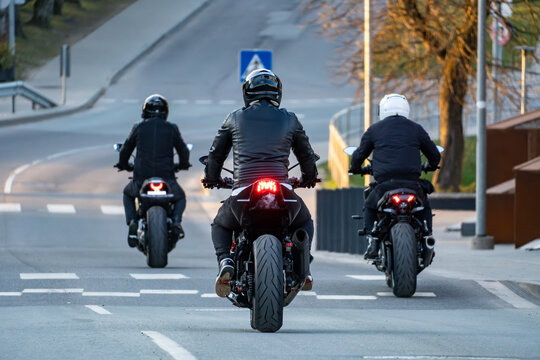 Three Motorcyclists Riding on a City Road.. Back View of Three Bikers on Motorcycles.