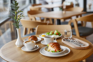Delicious breakfast served on wooden table in cafe