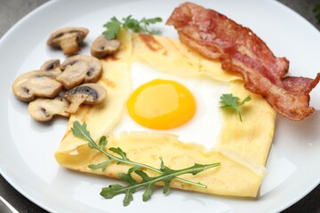 Delicious crepe bretonne with bacon, mushrooms and arugula on grey table, closeup