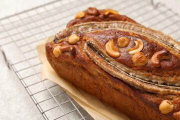 Delicious banana bread with nuts on light table, closeup