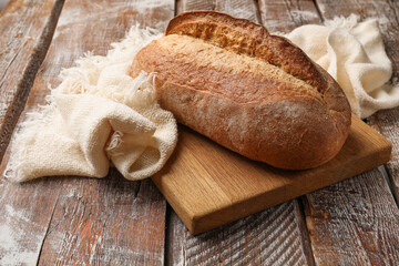 Fresh loaf of bread on wooden table, closeup